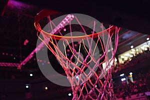 basketball hoop in red neon lights in sports arena during game