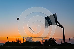 Basketball hoop silhouette soccer ball midflight baseball bat hits photo