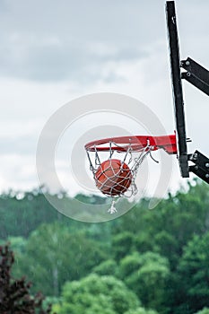 Basketball in hoop on street background. Street basketball