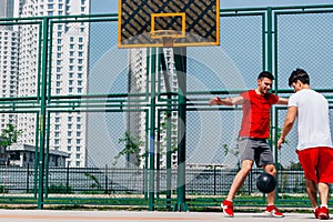 Basketball match. Playing ball with a black ball wearing red, grey and white colors