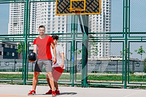 Basketball match. Playing ball with a black ball wearing red, grey and white colors