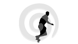 Basketball moves and stuffing the ball under his foot. Side view. Silhouette