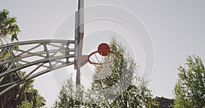 Basketball, net and goal at court or park for outdoor game, shot or score point in hoop or match. Ball flying high in