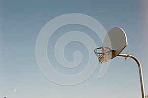 A basketball net hangs in the winter sky
