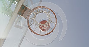 Basketball, net and miss below at court or outdoor park with blue sky for game, shot or score point in match. Basket