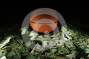 Basketball on a pile of cash -- money and betting in sports concept