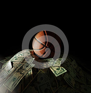 Basketball on a pile of money, on black background