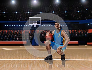 Basketball player in blue uniform sitting on basketball court