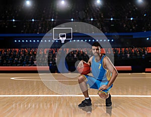 Basketball player in blue uniform sitting on basketball court