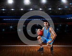 Basketball player in blue uniform sitting on basketball court