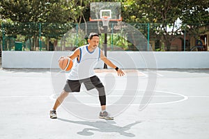 a basketball player doing a high dribble with the ball while practicing basketball