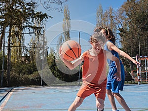 Basketball player dribbling another in match.