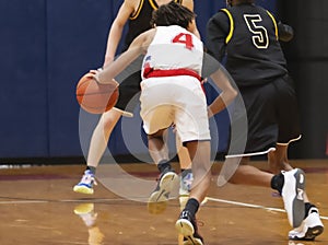 Basketball player dribbling the ball towards the defenders during a game