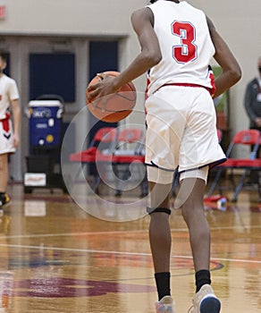 Basketball player dribbling the ball up the court during a game