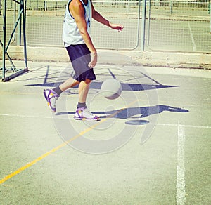 Basketball player dribbling in a playground