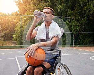 Basketball player, drinking water or man in wheelchair for sports break, rest or fitness electrolytes on court. Person