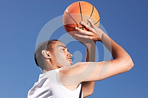 Basketball, player and game shoot in blue sky on outdoor court as fitness challenge or sports train, match as athlete