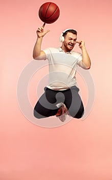 Full length portrait of young successfull high jumping man gesturing isolated on pink studio background