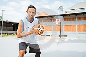 a basketball player holding a basketball with a pose ready to dribble the ball