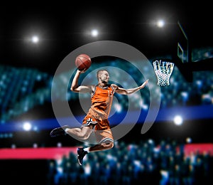 Basketball player making slam dunk on basketball arena photo