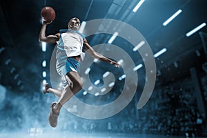 Basketball player on big professional arena during the game. Basketball player making slam dunk. photo