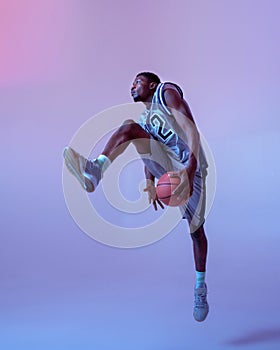 Basketball player moving with ball in studio