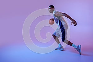 Basketball player practicing with ball in studio