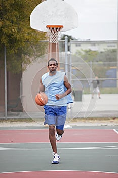 Basketball player running and dribbling the ball