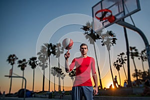 Basketball player shooting ball in hoop outdoor court. Urban youth game. Hand spinning basket ball. Balancing basketball