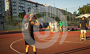 Basketball player shooting on a court outdoors in summer days