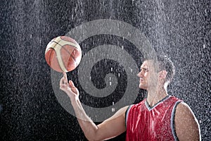 Basketball player spinning ball on a big rain
