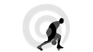 Basketball player stands and stuffing the ball under his foot. Silhouette