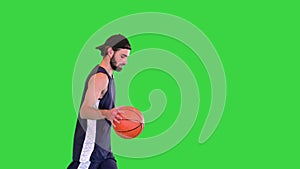 Basketball player throwing the ball after getting it while walking on a Green Screen, Chroma Key.