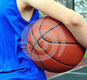 Basketball player wearing blue uniform with the ball