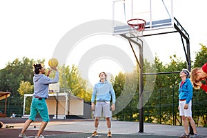Basketball players outdoors. summer vacation, holidays, games and friendship concept