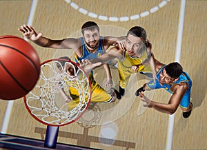 Four basketball players during scrimmage on nasketball arena photo