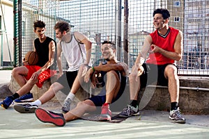 Basketball players take a break sitting on a low wall