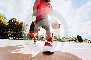 Basketball street player dribbling with ball on the court