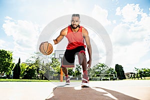 Basketball street player dribbling with ball on the court