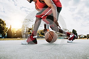 Basketball street player dribbling with ball on the court