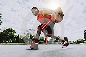 Basketball street player dribbling with ball on the court