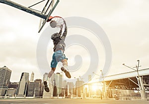 Basketball street player making a rear slam dunk.