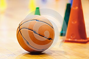 Basketball Training Game Background. Basketball on Wooden Court Floor Close Up with Blurred Training Cones