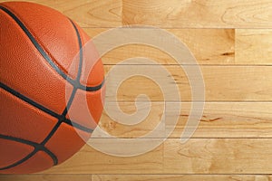 Basketball on wood gym floor viewed from above