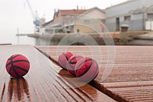 Four red basketballs on the panels of the harbor dull day photo