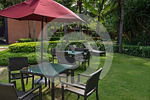 The basketry chair, table and red umbrella set in the garden, in the relax area