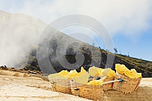 Baskets laden by natural sulfur in Kawah Ijen volcano mine photo