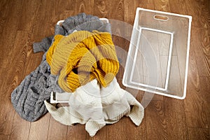 Baskets with a pile of knitted woolen clothes and an empty metal basket.