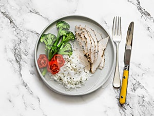 Basmati rice, broccoli and  baked chicken breast on a light background, top view. Delicious balanced lunch