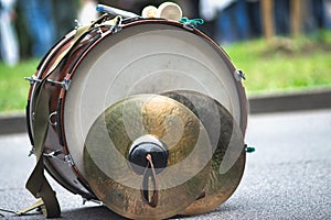 A bass drum with fanfare cymbals resting on the ground photo